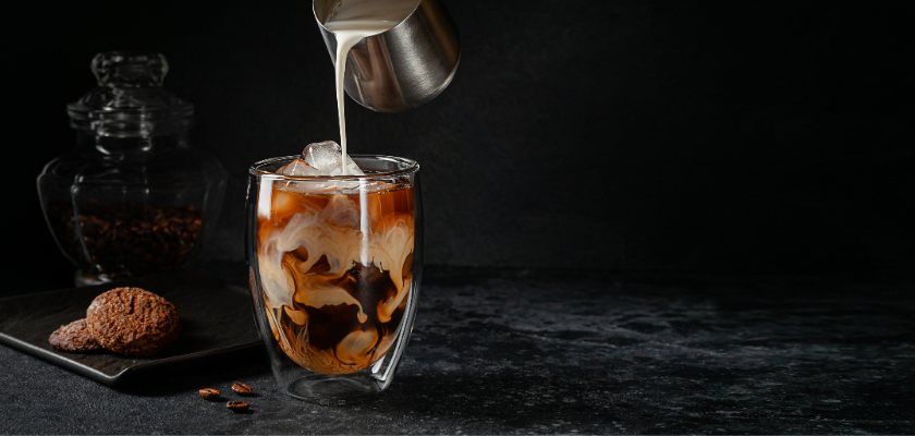Kremasta ledena kava - Dalgona servirana u staklenoj šalici s ledom. 